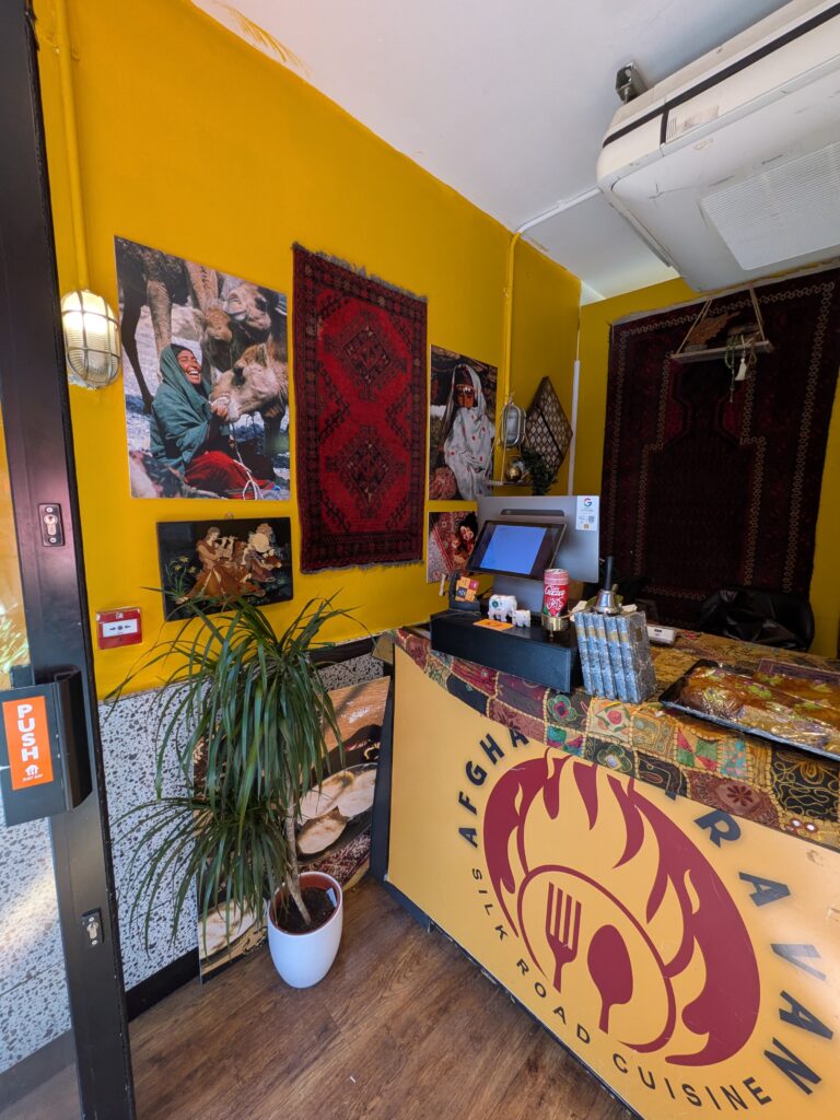 The home of Afghan Caravan with pictures on the dark yellow walls.